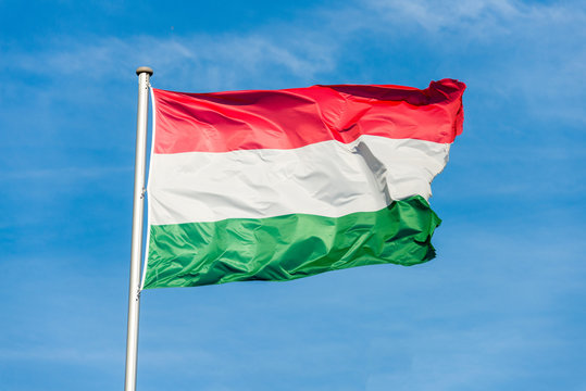 Hungarian flag waggling in the wind with sky in background