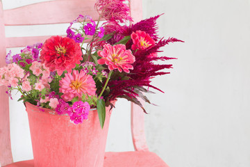 pink flowers in bucket on white background