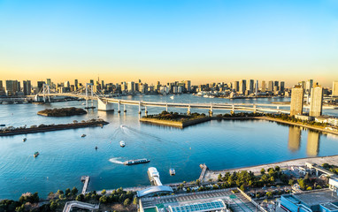 Asia Business concept for real estate and corporate construction - panoramic modern city skyline bird eye aerial view of Odaiba, tokyo tower & rainbow bridge under golden sun in Tokyo, Japan