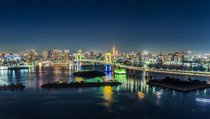 Asia Business concept for real estate & corporate construction - panoramic modern city skyline view  of tokyo tower & rainbow bridge with neon night in Odaiba, Tokyo, Japan.