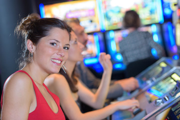 happy young friends having fun together with slot machine