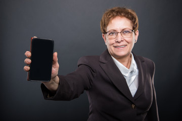Selective focus of business senior lady showing smartphone