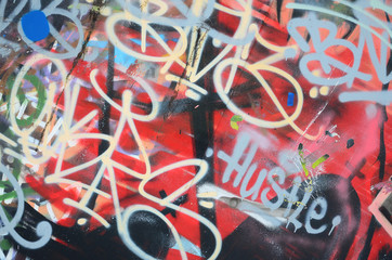 Close-up fragment of a graffiti drawing applied to the wall by aerosol paint. The wall is spoiled...