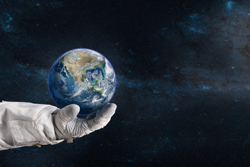 Earth in the hand of astronaut. Earth Day concept. Elements of this image furnished by NASA.