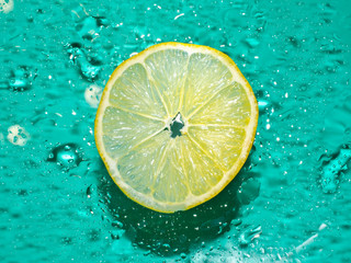 .Cross-section of the juicy lemon on blue background .