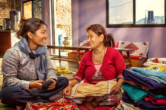 Mother and Daughter Folding the Laundry, Nepal
