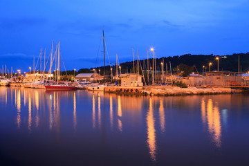 Yachts moored in the harbor channel in Pesaro, Marche, Italy. Night view.