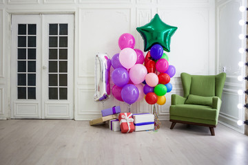 balloons of different colors with gifts for the holiday in a room