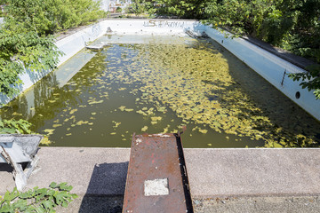 Abandoned public swimming pool in Thailand, construction concept, dirty water in old swimming pool