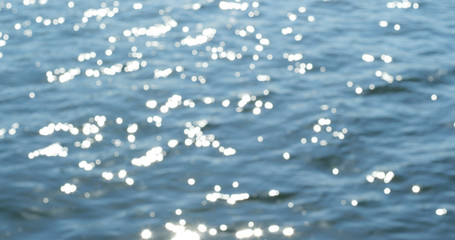 Blue sea water surface at sunset with sparks