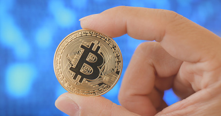Hand holding bitcoin over digital abstract background