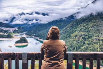 Traveler enjoying the panoramic view of lake of Centro Cadore in the Alps in Italy, Dolomites, near Belluno.