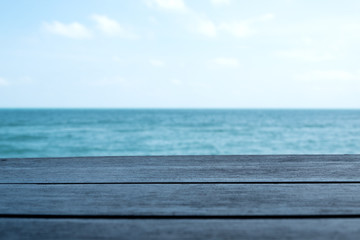 Fototapeta premium Drewniany stół z tłem morza i błękitnego nieba