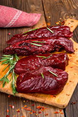 Smoked red deer maral filleted on a wooden background