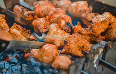 Meat close-up on the grill. Hot meat on charcoal on a sunny afternoon in the park. Summer holidays with friends. Background blur. Best pastime in the summer.