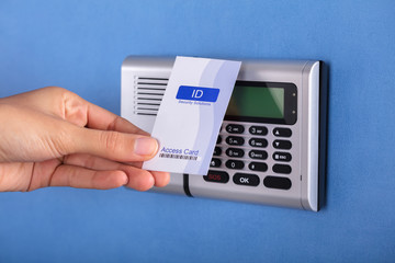 Person Holding Key Card Near Security System