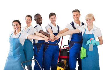 Group Of Happy Janitors Stacking Hands