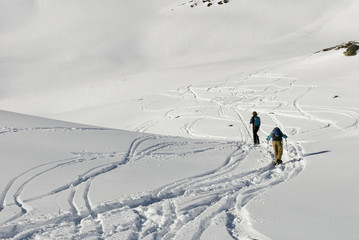 Background: man and woman, sporty, walking with snowshoes in fresh snow, high mountains, sunny and...