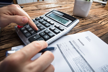 Person's Hand Calculating Invoice