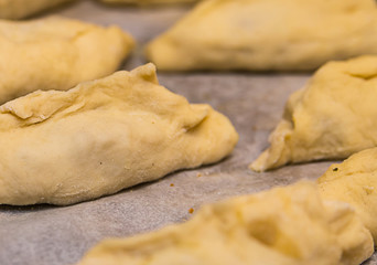 raw pie billet thin dough with minced meat close-up, part of the product home bakery