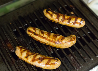 appetizing meat sausages with stripes from the grill on background of lattice bbq nourishing appetizer for beer