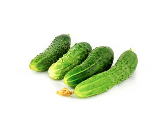 four delicious little prickly green cucumbers light bite on a white isolated background