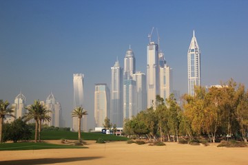 Fototapeta na wymiar GOLF COURSE WITH DUBAI MARINA SKYSCRAPER AS BACK GROUND, DUBAI UAE