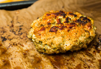 chopped meat cutlet with dill baked in the oven with an appetizing crust against the background of parchment