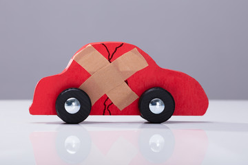 Broken Car With Cross Band Aid