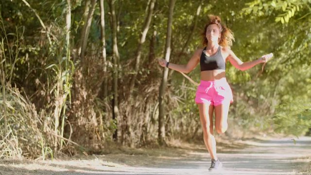 Woman is jumping rope in the park. shot in slow motion