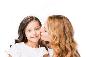 portrait of mother kissing little daughter isolated on white