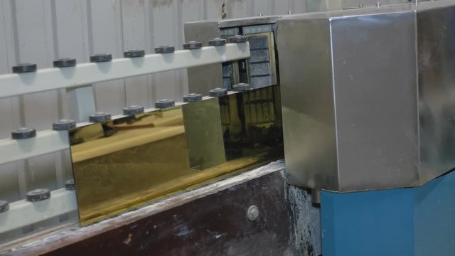 Processing of the edge of the glass with gold coating on the machine tool with program control. Factory for the production of windows.