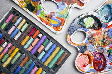 Multicolored crayons pastel and palette with paints. Creation.