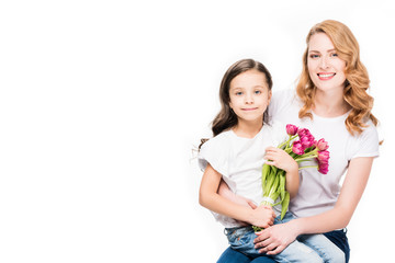 happy mother and little daughter with bouquet of flowers isolated on white, mothers day holiday concept