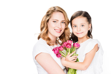 portrait of happy mother and little daughter with bouquet of flowers isolated on white, mothers day holiday concept