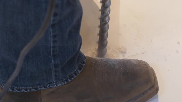 A man drilling with a hammer drill on a construction site