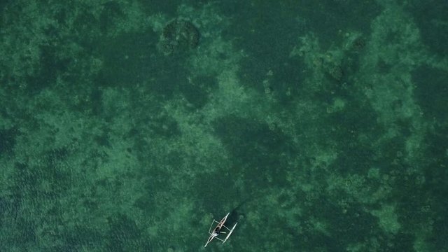 Birds eye view of fisherman on pirogue boat on sea