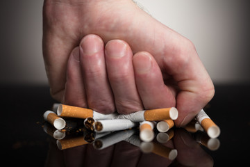 Man's Fist Crushing Cigarettes