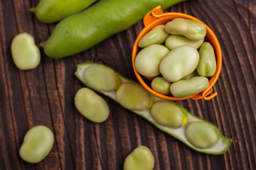 fresh broad beans on a rustic background
