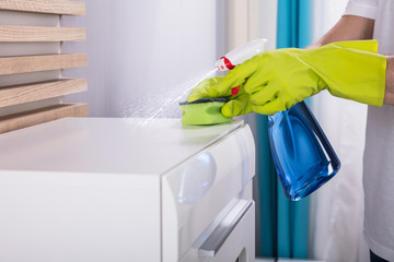 Person Cleaning Furniture With Spray Bottle