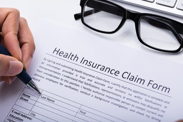 Person Filling Health Insurance Claim Form