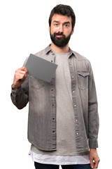 Handsome man with beard holding a grey card on white background