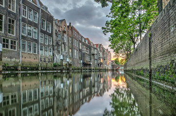 Obraz premium View at sunset of a canal in downtown Dordrecht, The Netherlands with houses built directly on the waterside