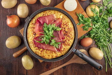 Spanish tortilla, shot from above with ingredients and copyspace