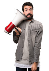 Handsome man with beard holding a megaphone on white background