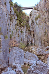 Fototapeta na wymiar Small bridge and big stones in the ravine