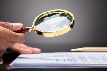 Judge Looking At Document With Magnifying Glass