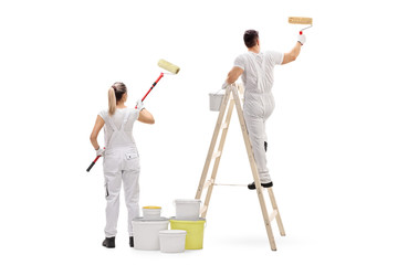 Female painter and a male painter climbed up a ladder painting