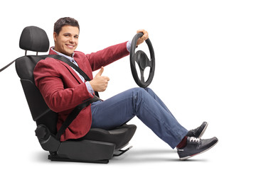 Elegantly dressed man seated in a car seat driving and making a thumb up sign
