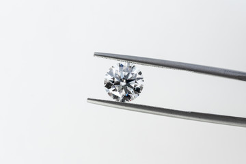 Round cut diamond in tweezers